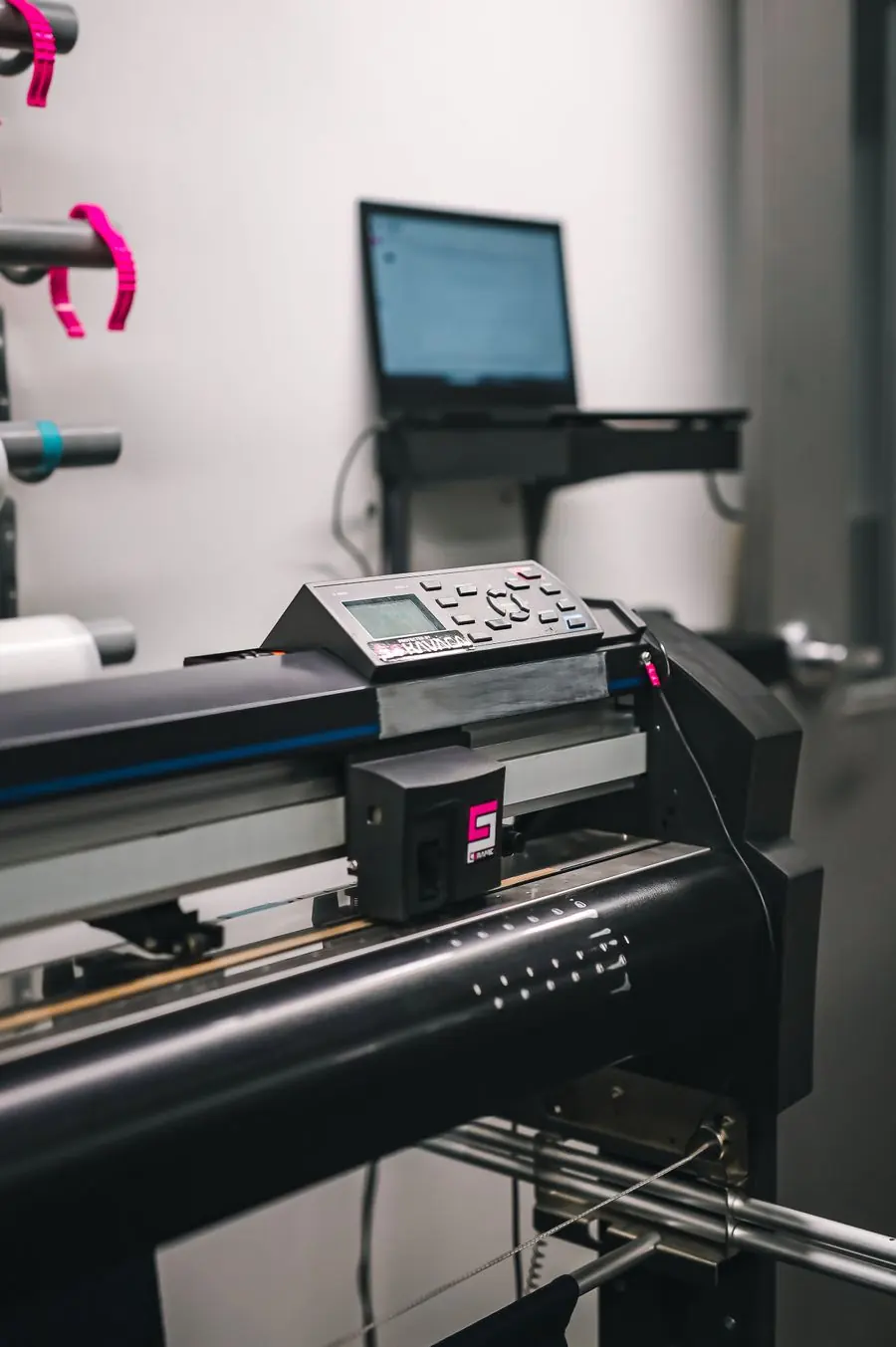 Mesin cutting plotter dengan laptop di bengkel produksi sticker